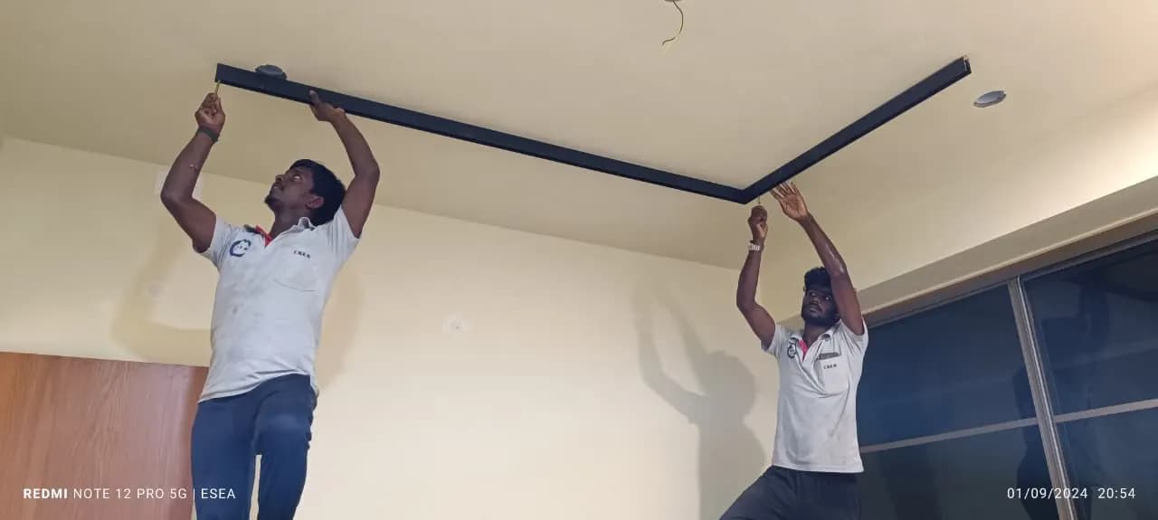 Two ESEA technicians fixing a ceiling light profile in a bedroom